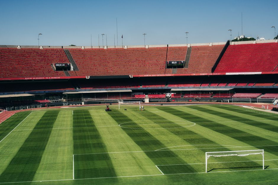 Aerial view of an empty soccer stadium with a vibrant green field, ready for a match.